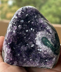 Polished amethyst stalactite slice with visible stalactite core and purple druzy crystals. Natural geode specimen for collectors and décor.
