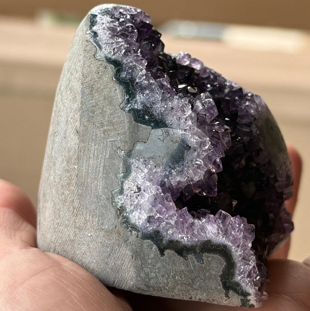 Polished amethyst stalactite slice with visible stalactite core and purple druzy crystals. Natural geode specimen for collectors and décor.