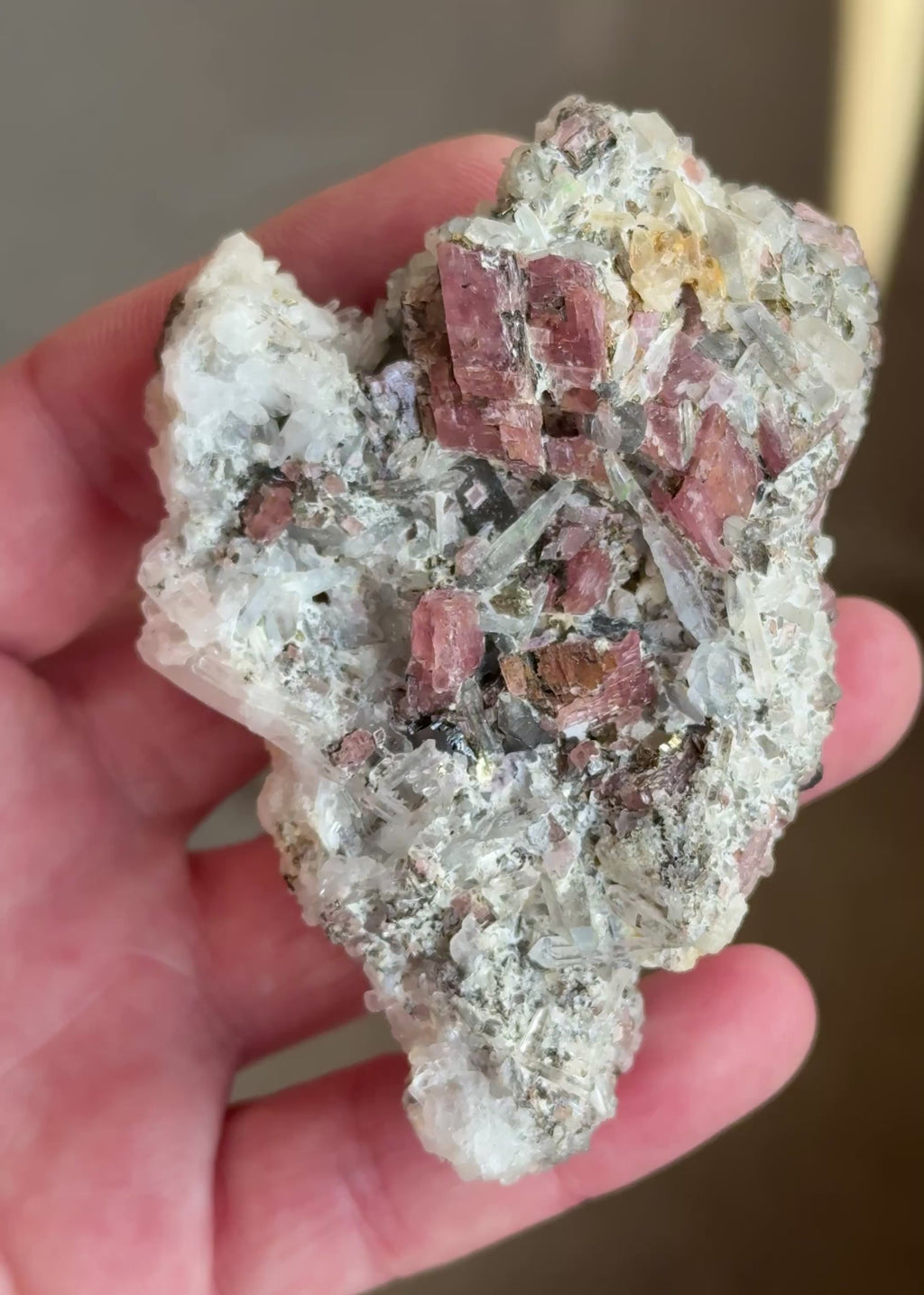 Cherry-red rhodochrosite rhombohedrons perched on a matrix of crystallized tetrahedrite and sparkling needle quartz, accented by bright brassy pyrite and rare lavender-to-purple fluorite crystal