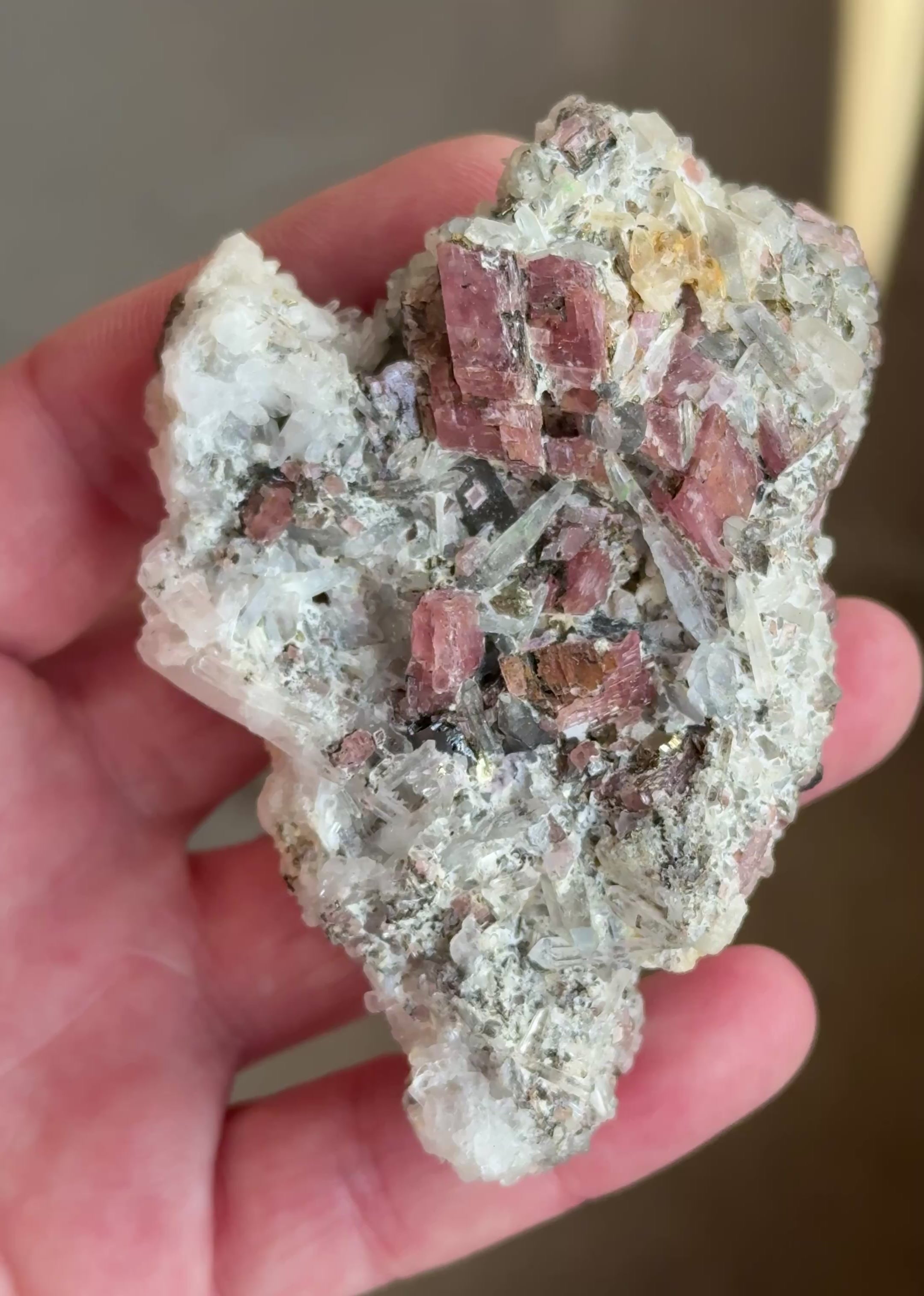 Cherry-red rhodochrosite rhombohedrons perched on a matrix of crystallized tetrahedrite and sparkling needle quartz, accented by bright brassy pyrite and rare lavender-to-purple fluorite crystal